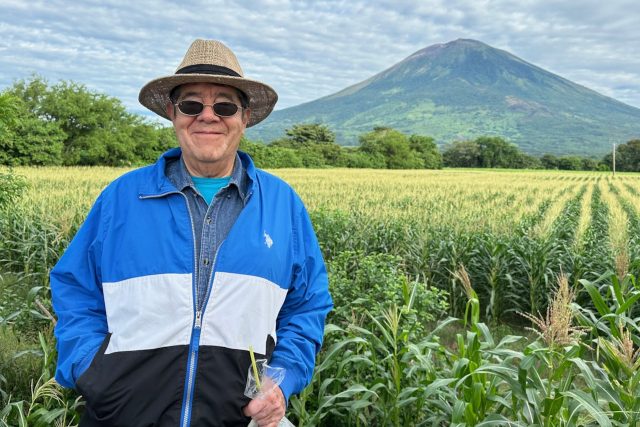 Salvador Dávila visitando El Salvador con el volcán Chaparrastique en el fondo.