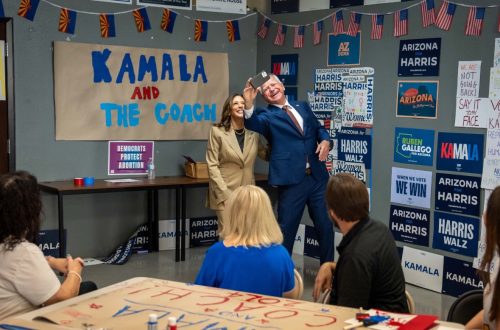 Kamala Harris and Tim Walz in front of a banner that reads: Kamala and the Coach.